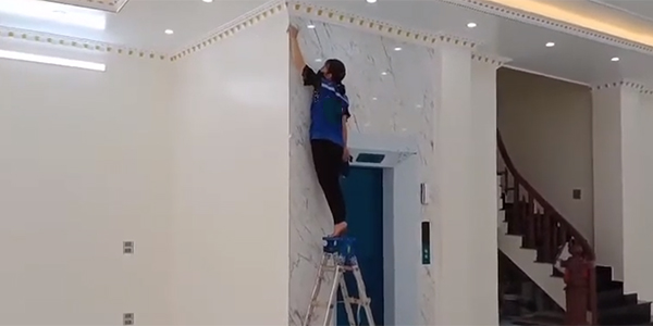 Nhân viên dịch vụ vệ sinh sau xây dựng đang vệ sinh tường công trình cho khách hàng