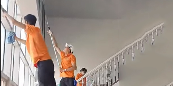 Nhân viên dịch vụ vệ sinh sau xây dựng đang tiến hành dọn dẹp, làm sạch công trình cho khách hàng